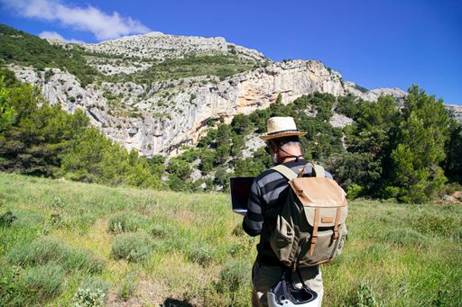 A traveler searching something on netbook computer in the mountains
