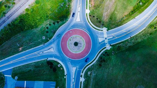 An aerial shot of a roundabout with a red circle in the middle