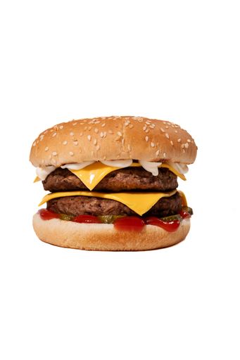 Close-up of a double cheeseburger with sesame bun and condiments.