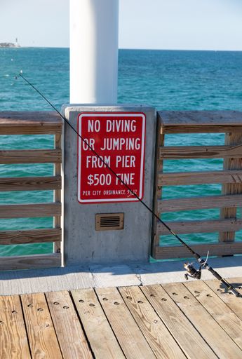A vertical shot of a sign on the Pompano Beach Public Pier in Pompano Beach, FL
