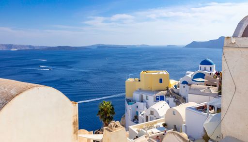 A scenic view of Santorini's iconic white buildings and blue domes overlooking the Aegean Sea