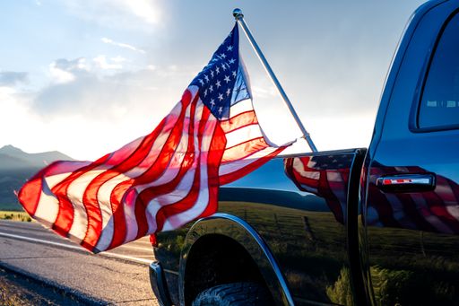 The USA flag sticking from the black pickup truck cargo in Bridgeport, California, USA