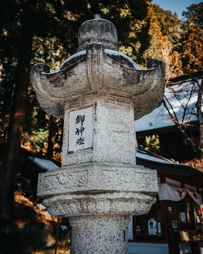 An ornate ancient Japanese stone lantern at Shinto shrine in Fuji Fujikawaguchiko Japan
