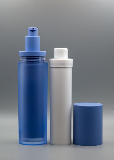 Two cosmetic bottles, one blue and one white, with a blue cap on a gray background