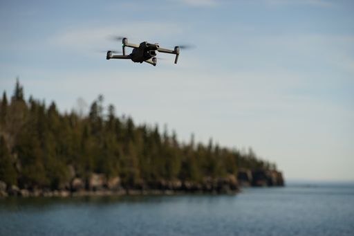 A DJI air 2s drone photography over the lake with trees in the blurry background