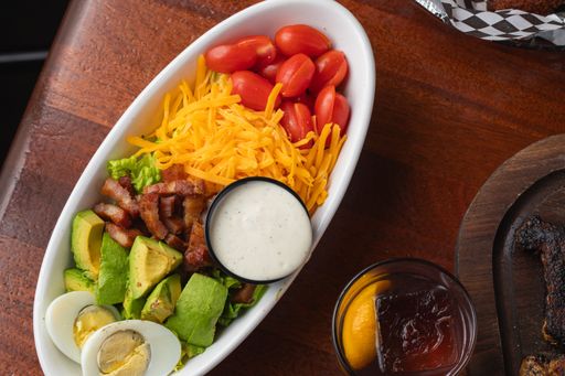A top view of salad with cherry tomatoes, bacon, avocado and boiled eggs
