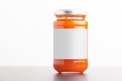A homemade carrot jam in a glass jar on a white background, editable mock-up series template