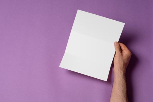 Male hands holding a tri-fold brochure with blank pages on purple background, mock-up series template