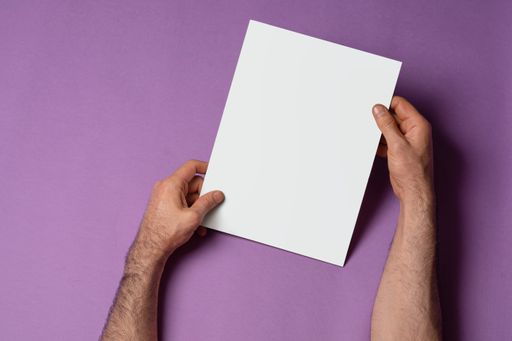 Male hands holding a tri-fold brochure with blank pages on purple background, mock-up series template