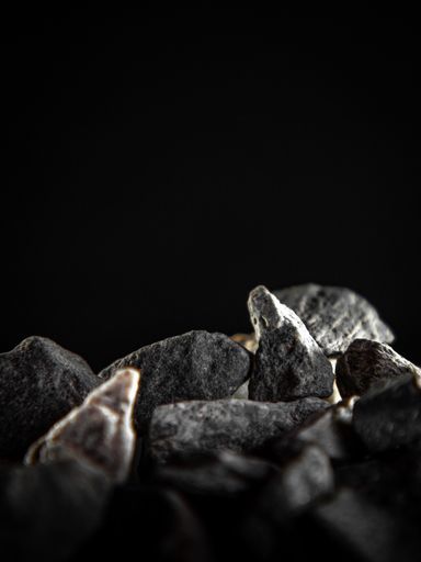 A vertical shot of gray stones piled on one another under a ray of light
