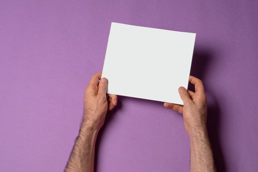 Male hands holding a tri-fold brochure with blank pages on purple background, mock-up series template