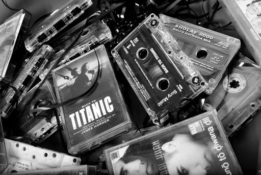 A grayscale picture of a few Cassette tapes of popular movies and music