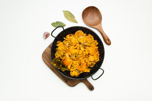 A top view of paella with seafood with ingredients isolated on a white background