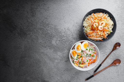 A top view of different dishes with noodles, eggs, and vegetables in bowls