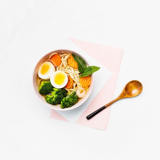 A top view of noodles with vegetables isolated on a white background