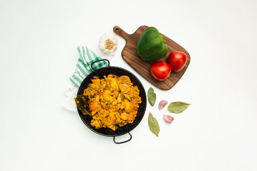 A top view of paella with seafood with ingredients isolated on a white background