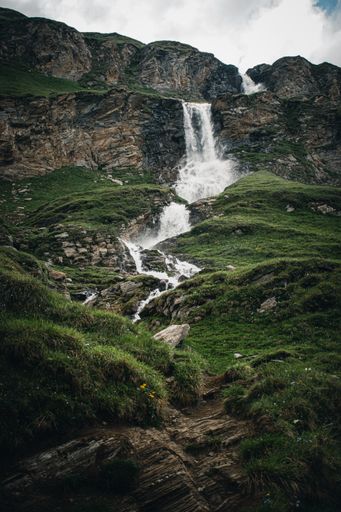 A vertical shot of a waterfall flowing over the rocks