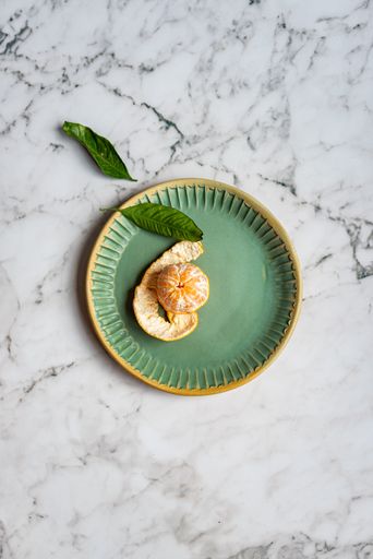 A plate with peeled orange fruit on the marble table