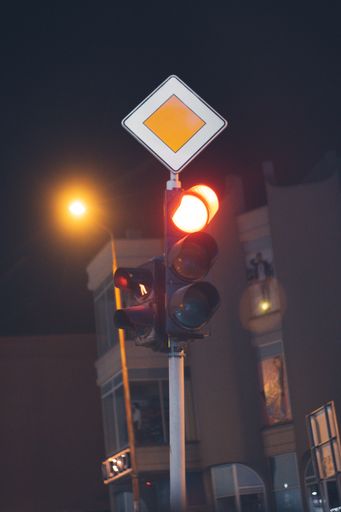 A vertical low angle shot of a traffic light at night