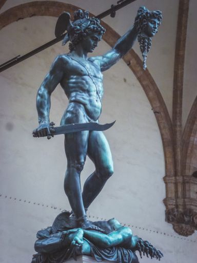 A vertical closeup shot of a man's statue holding a head in his hand in Florence Italy