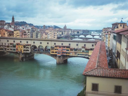 An aerial shot of Ponte Vecchio in Florence Italy under a blue sky