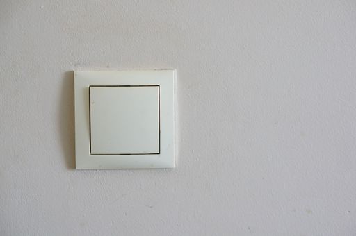 The light switch on the white wall in the room