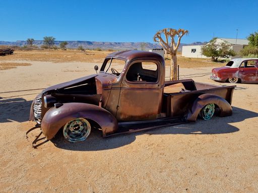 An old broken vintage car thrown in a desert