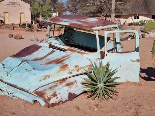 An old broken vintage car dumped in a desert