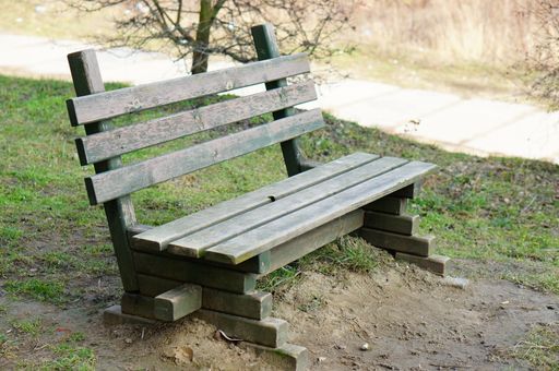 A wooden bench surrounded by grass in the park