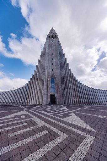 A stunning view of Hallgrimskirkja church in Reykjavik, Iceland with a blue sky and white clouds