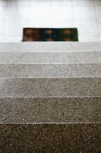 A vertical shot of several stairs leading to a carpet