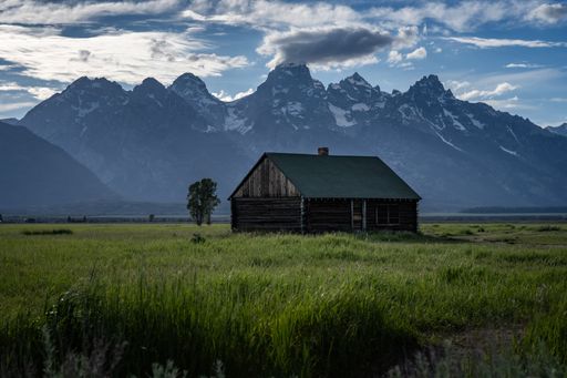 A scenic view of Mormon Row house in Grand Teton National Park with cloudy sky on the horizon