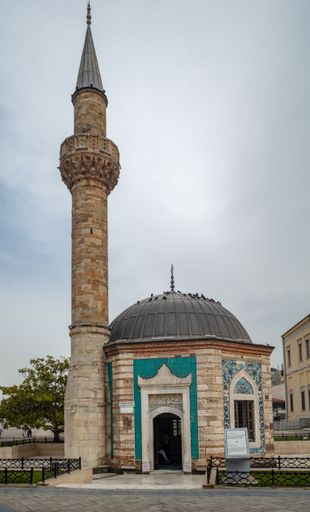 A vertical shot of the historical Konak Mosque (Yali Mosque) against cloudy sky in daytime in Konak, Izmir, Turkey