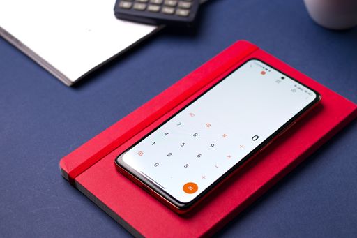 A smartphone displaying the calculator app with notes on a table