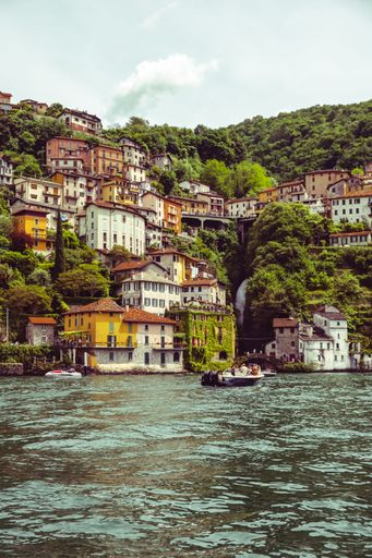 Scenic view of colorful buildings on a hillside by the water in a picturesque European village with boats in the foreground