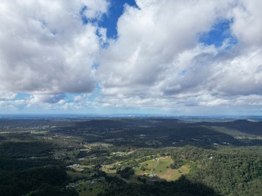 An aerial view of a mountainous landscape under a partly cloudy sky