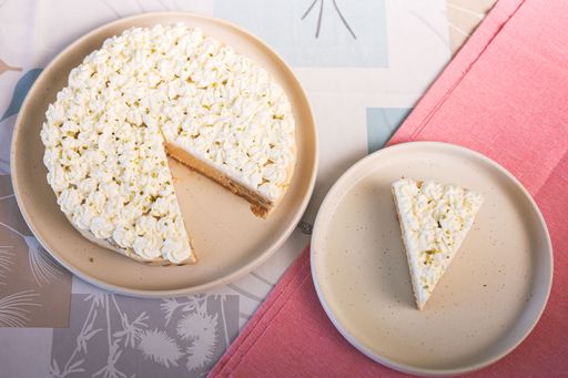 A top view of a delicious cake with a slice on a plate on a decorated table.