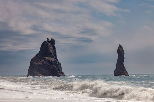 The view of sea waves and cliffs under a cloudy sky. Iceland