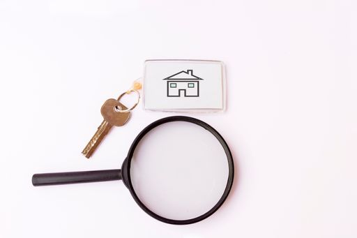 A top view of a magnifying glass and key with keychain isolated on white background
