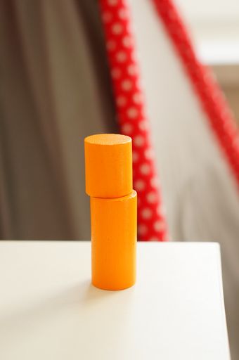 A closeup shot of two wooden orange block cylinders stacked on top of each other