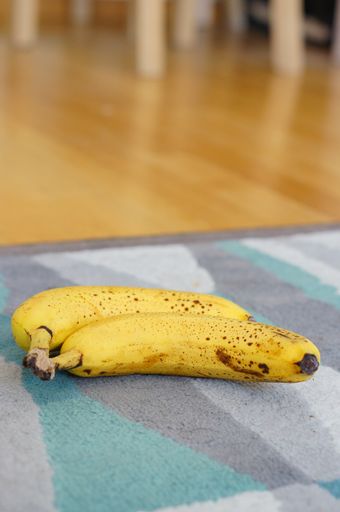 A vertical shot of a banana on the rug