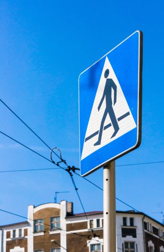 A vertical shot of a street sign showing a  pedestrian