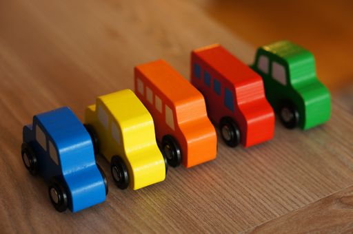 A high angle shot of colorful wooden toy cars
