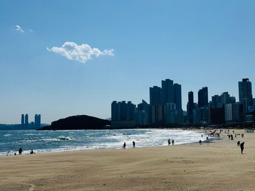 A sunny day at Haeundae Beach in Busan with people enjoying the sand and sea