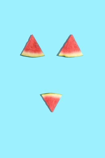 A vertical shot of watermelon slices as a bikini isolated on a pastel blue background