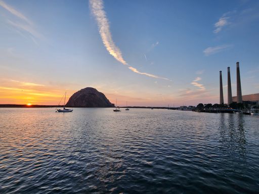 Amazing sunset view of Morro Bay with Morro Rock and boats on the water, California