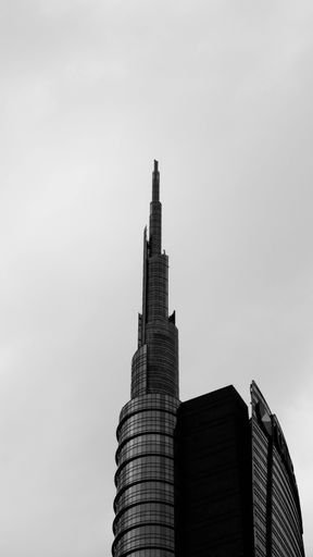 A black and white vertical photo of the Unicredit Tower in Milan, Italy
