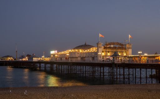 A pier with British flags and cafes in the evening