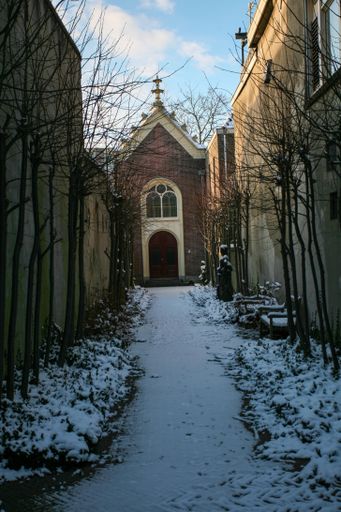 A vertical shot of a narrow pathway towards a church