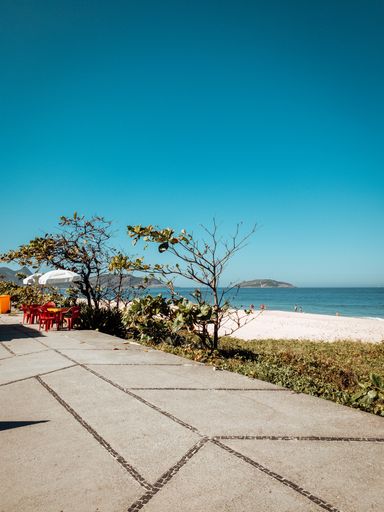 A vertical shot of the paved path along the sandy beach